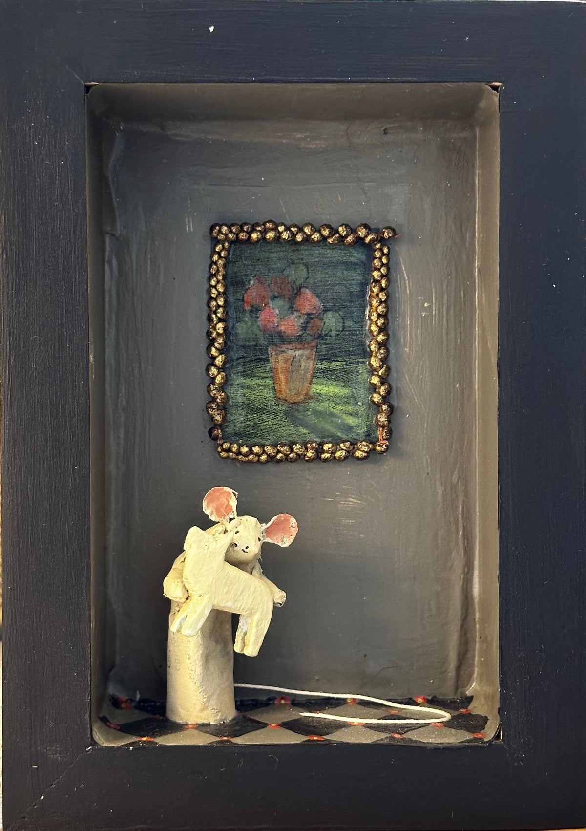 Mouse and painting of flowers in gold frame